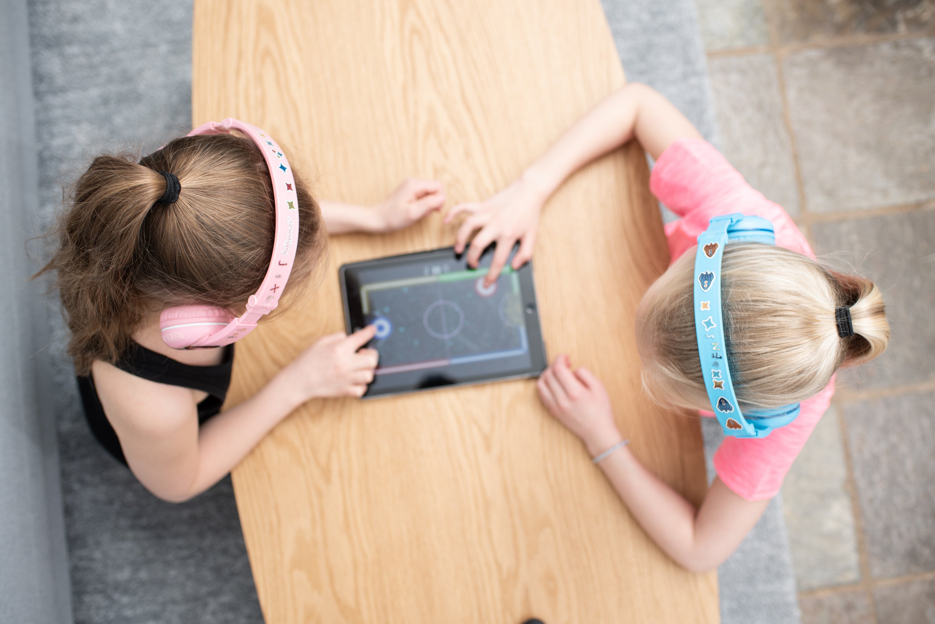 Kids headphones for girls. Girls using headphones while playing. Volume limiting headphones